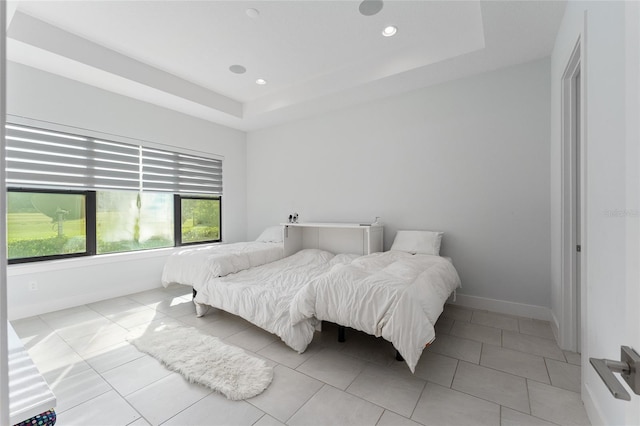 tiled bedroom featuring a raised ceiling