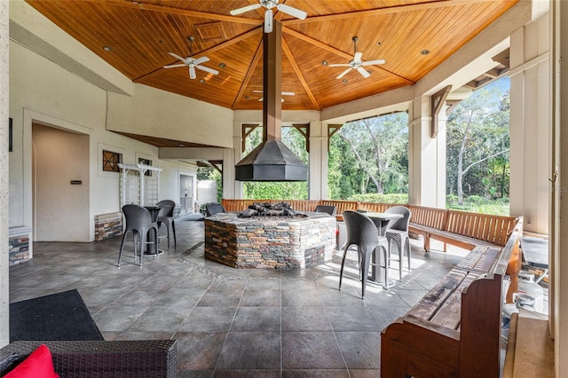 view of patio with a gazebo, an outdoor fire pit, ceiling fan, and exterior bar