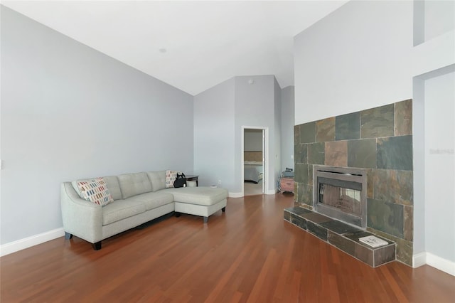 living room featuring a tiled fireplace and wood-type flooring