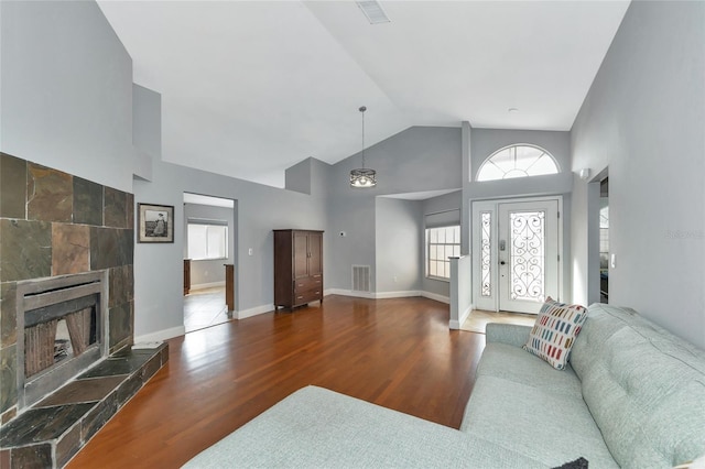 living room with vaulted ceiling, hardwood / wood-style floors, and a fireplace