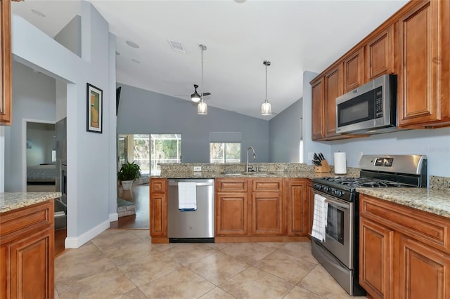 kitchen featuring stainless steel appliances, vaulted ceiling, light stone countertops, and sink