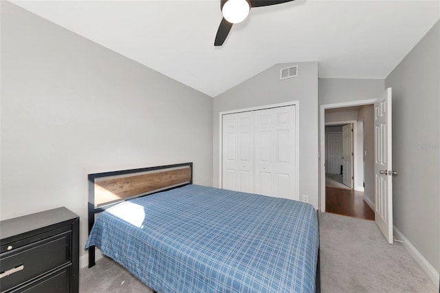 carpeted bedroom with vaulted ceiling, ceiling fan, and a closet