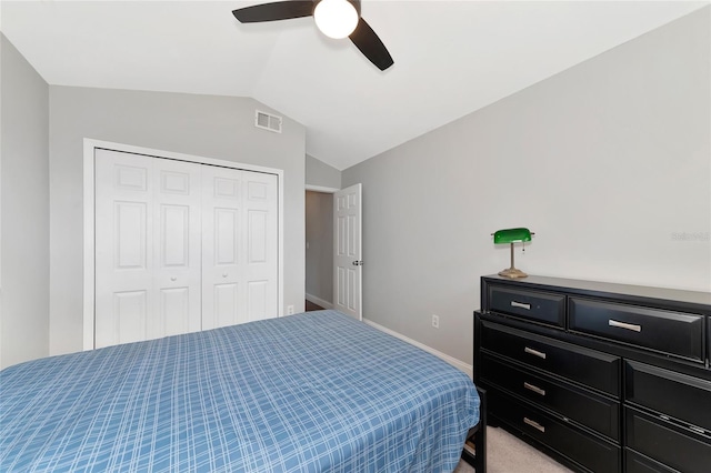 carpeted bedroom with ceiling fan, lofted ceiling, and a closet