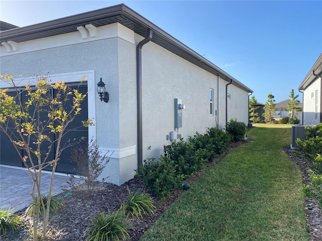 view of property exterior with central AC unit and a lawn