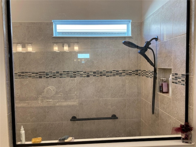 bathroom featuring tiled shower and plenty of natural light