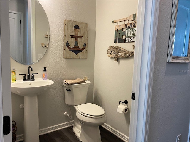 bathroom with wood-type flooring, toilet, and sink