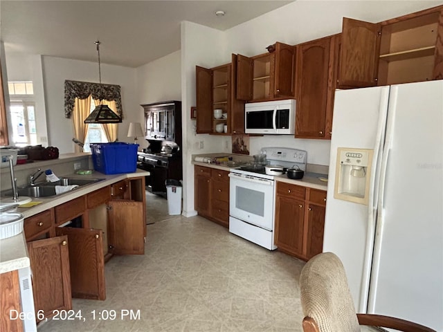 kitchen with white appliances, an inviting chandelier, hanging light fixtures, and sink