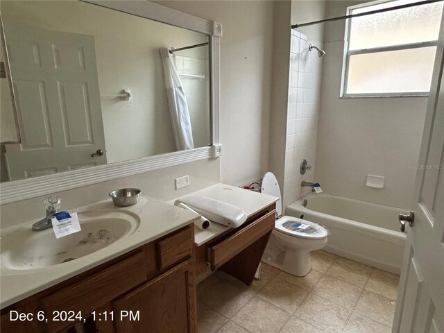 full bathroom featuring vanity, tiled shower / bath combo, and toilet