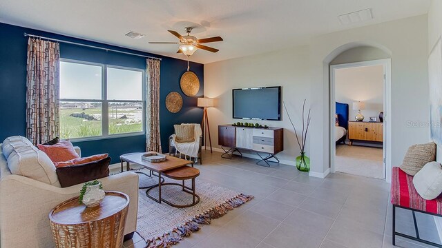 tiled living room with ceiling fan