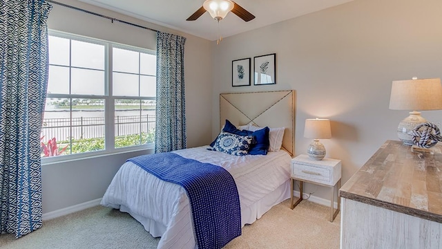 carpeted bedroom featuring multiple windows and ceiling fan