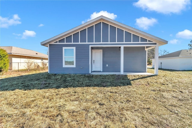 rear view of house with a patio and a lawn