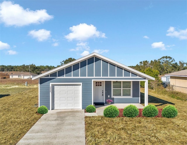 view of front of property featuring a garage, covered porch, and a front lawn