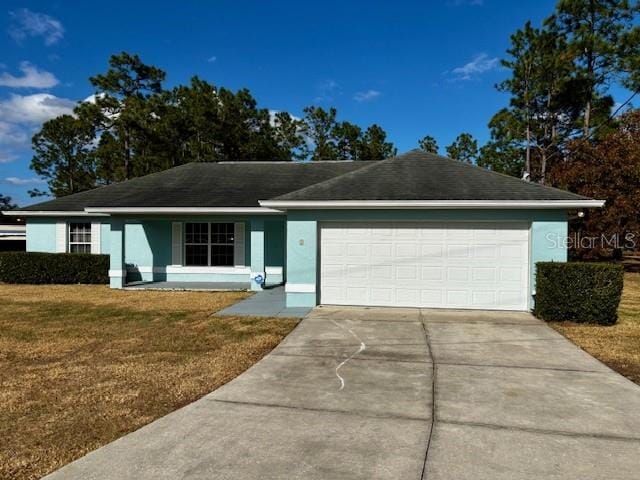 ranch-style house with a garage and a front lawn