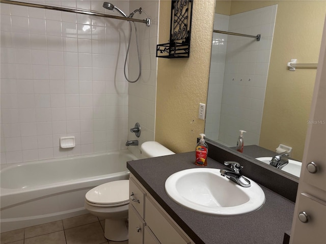 full bathroom with tile patterned flooring, vanity, tiled shower / bath combo, and toilet