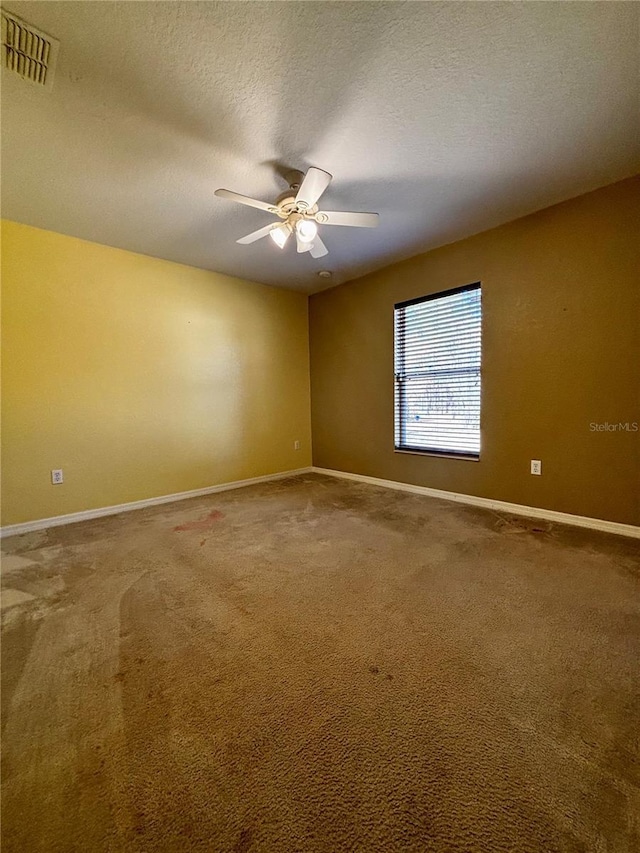 carpeted empty room featuring ceiling fan and a textured ceiling