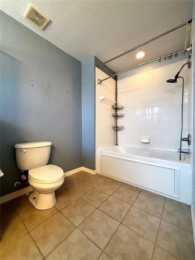 bathroom with tile patterned flooring, tiled shower / bath combo, a textured ceiling, and toilet