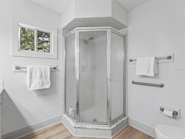 bathroom with hardwood / wood-style flooring, toilet, an enclosed shower, and vanity