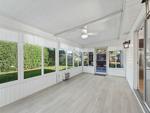 unfurnished sunroom with a wall mounted AC and ceiling fan