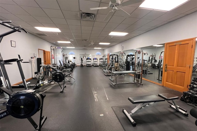 gym with a paneled ceiling and ceiling fan