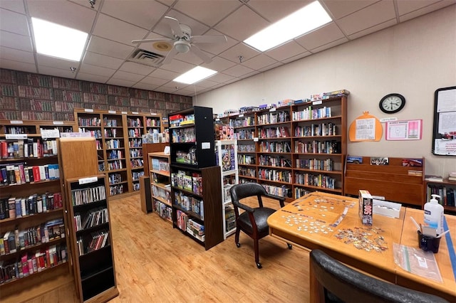 office space featuring light hardwood / wood-style flooring, a drop ceiling, and ceiling fan