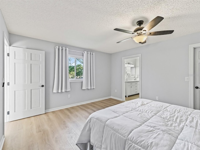 bedroom with a textured ceiling, light hardwood / wood-style floors, ensuite bath, and ceiling fan