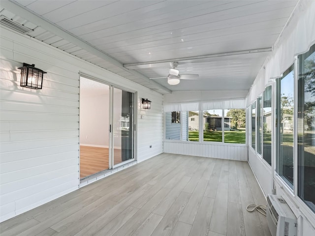 unfurnished sunroom with vaulted ceiling with beams, ceiling fan, wooden ceiling, and a wall mounted air conditioner