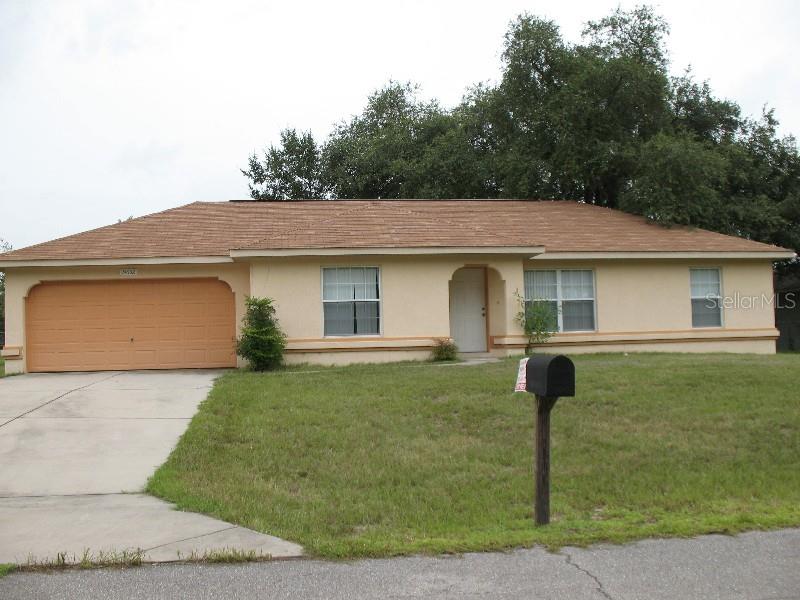 single story home featuring a garage and a front lawn