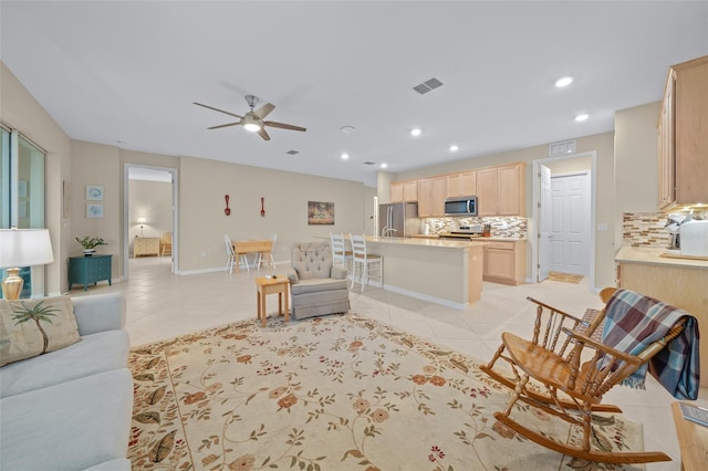 living room featuring light tile patterned floors and ceiling fan