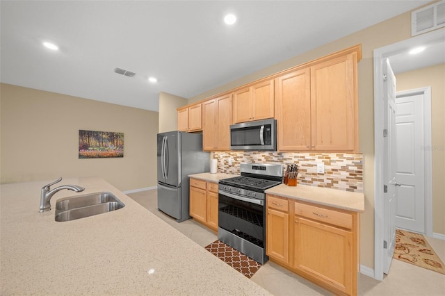 kitchen featuring tasteful backsplash, light brown cabinetry, sink, and stainless steel appliances