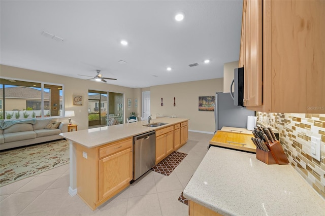 kitchen featuring light brown cabinets, a kitchen island with sink, sink, light tile patterned floors, and appliances with stainless steel finishes