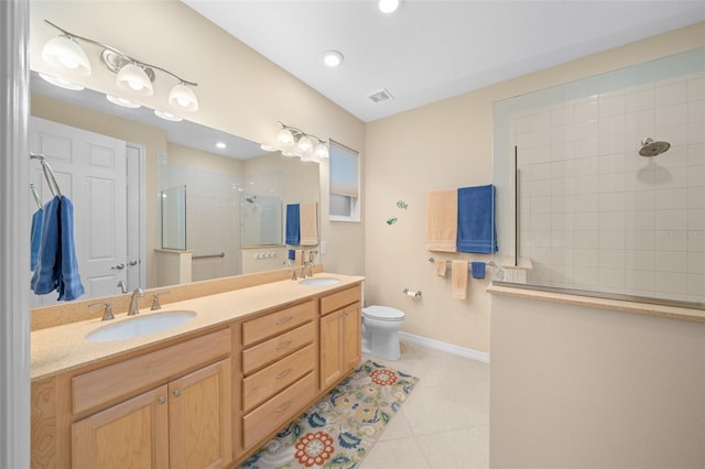 bathroom with tile patterned floors, toilet, vanity, and tiled shower