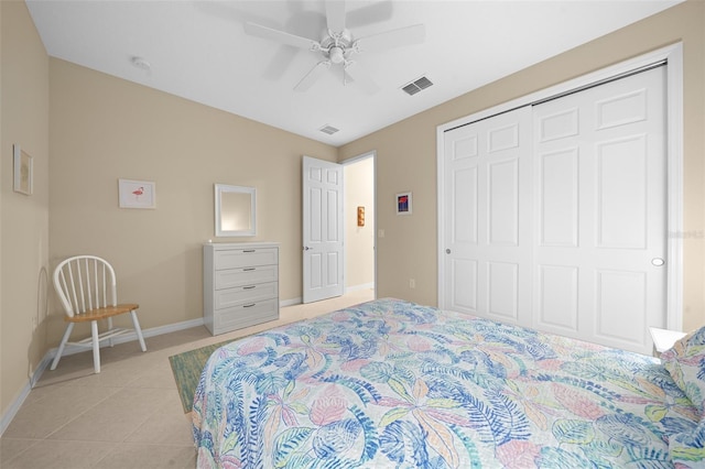 tiled bedroom featuring ceiling fan and a closet