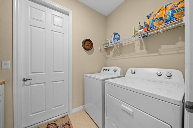 laundry area featuring washing machine and dryer and light tile patterned floors