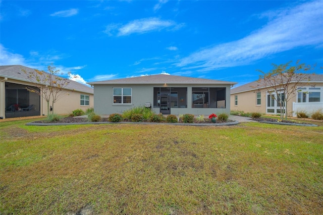 rear view of house with a sunroom and a yard