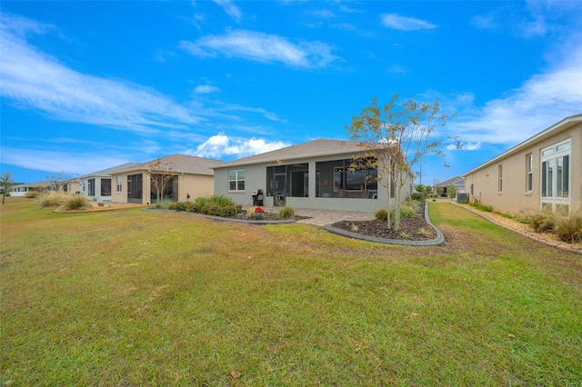 rear view of property with a lawn and a sunroom