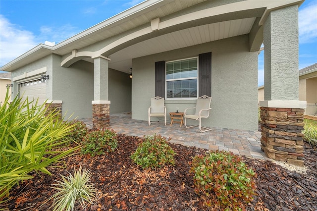 doorway to property featuring covered porch and a garage