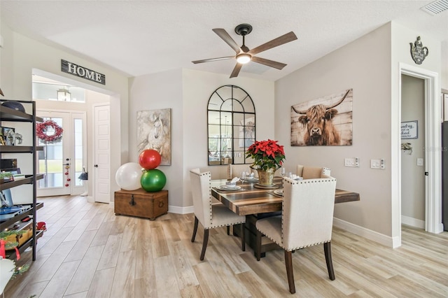 dining space featuring a textured ceiling, light hardwood / wood-style floors, plenty of natural light, and ceiling fan