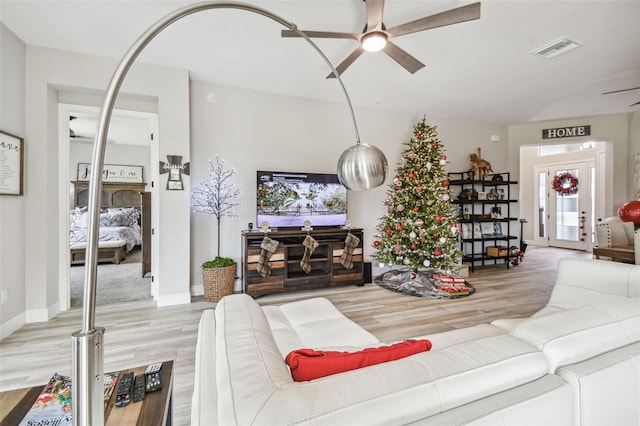 living room with ceiling fan and light wood-type flooring