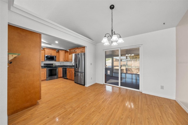 kitchen featuring stainless steel appliances, an inviting chandelier, light hardwood / wood-style floors, vaulted ceiling, and decorative light fixtures