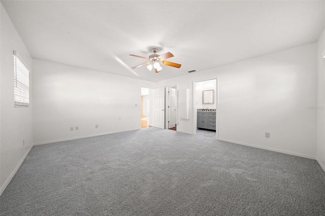 unfurnished bedroom with ensuite bath, ceiling fan, and light carpet