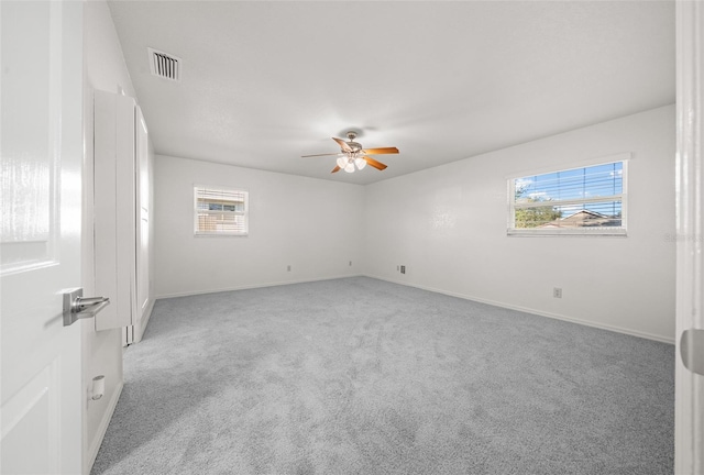 spare room featuring light carpet and ceiling fan