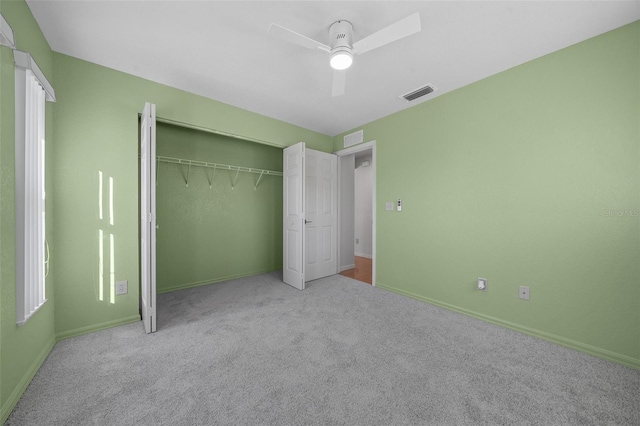 unfurnished bedroom with ceiling fan, light colored carpet, and a closet