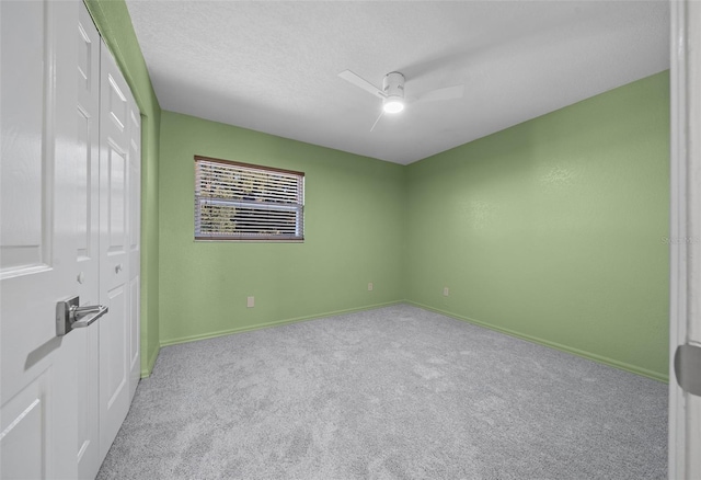 unfurnished bedroom with ceiling fan, light colored carpet, and a closet