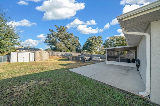 view of yard featuring a sunroom, a storage unit, and a patio area