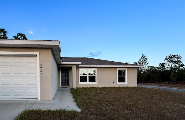 view of exterior entry with a lawn and a garage