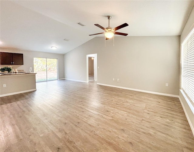 unfurnished living room featuring ceiling fan, light wood-type flooring, and vaulted ceiling