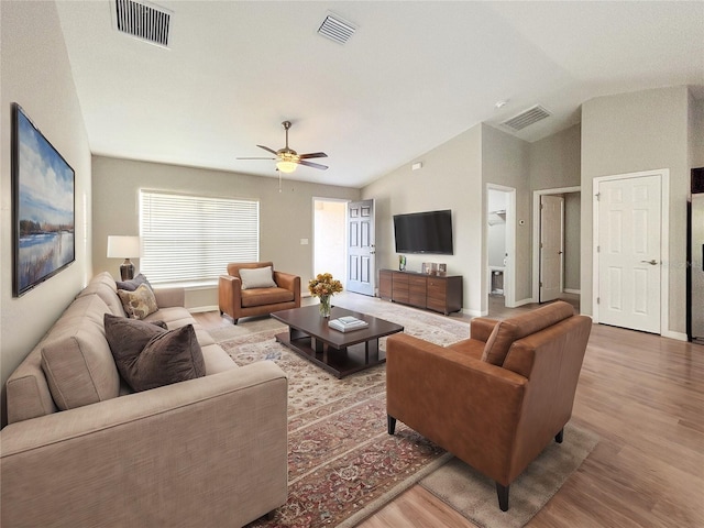 living room with ceiling fan, wood-type flooring, and vaulted ceiling