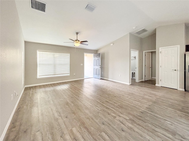 empty room with ceiling fan, light hardwood / wood-style floors, and vaulted ceiling