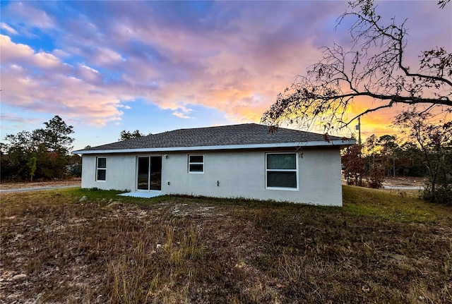 back house at dusk with a yard