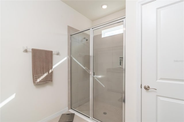 bathroom with an enclosed shower and tile patterned flooring